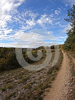 Hiking path in nature park of Les Eaux Claires valley, cliffs and blue sky, in the Charente, France