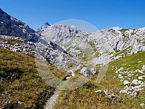 Hiking path through rocky landscape surrounded by Sulzfluh and Scheienfluh in Praettigau, Graubuenden, Switzerland.