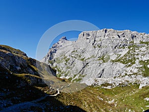 Hiking path through rocky landscape surrounded by Sulzfluh and Scheinfluh in Praettigau, Graubuenden, Switzerland.