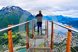 Hiking Rampestreken. Tourist man on the Rampestreken Viewpoin. Panoramic landscape Andalsnes city in Norway