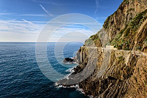 Hiking road at rocky coastline of Riomaggiore town in Cinque Terre national park, Italy