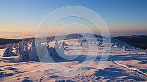 Hiking route on snowed up mountain ridge in winter at sunrise light