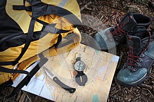 Hiking shoes on map with compass