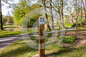 Hiking sign for disabled people in a park, drawing and the word Rolstoel means wheelchai