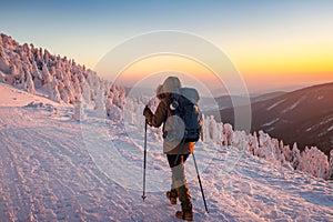 Hiking in snow at winter mountain during sunset