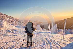 Hiking in snow at winter mountain during sunset