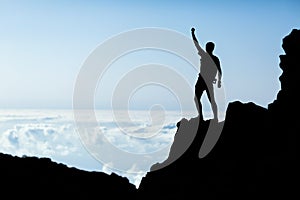 Hiking success silhouette, man trail runner in mountains