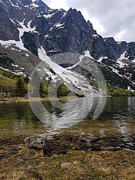 Hiking in Tatra National Park, Poland, in May. Beautiful panoramic view on rocky and snowy mountains, and famous mountains lake