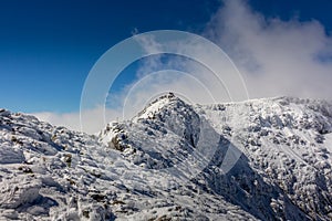 Hiking to the Maliovica summit after a cold winter storm at the Rila mountain in Bulgaria, Maliovica