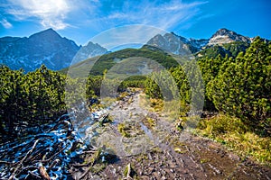 Turistika na horské jezero v národním parku Vysoké Tatry na podzim a slunečný den. Dramatická zatažená obloha. Zelené pleso, Slovensko, Evropa