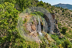 Hiking track over waterfall with tourists in Chera, Spain