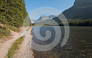 Hiking trail along shore of Fishercap Lake on the Swiftcurrent hiking trail in Glacier National Park in Montana USA photo