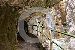 Hiking trail Cares Trail or Ruta del Cares in the narrow tunnel along river Cares in cloudy spring day near Cain, Picos de Europa photo