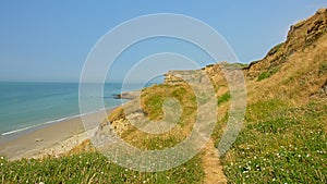 Hiking trail in a field on the ciffs along the beach off the French Northe sea coast, with the city of Wiemereux in the background