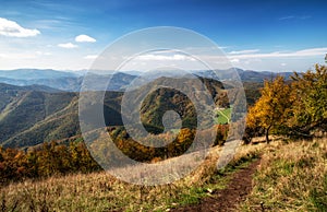 Hiking trail on the hill with colorful autumn mountains