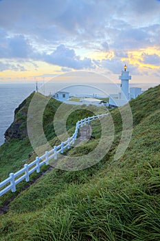 Hiking trail leading to a lighthouse on the cliff in northern coast of Taiwan at sunrise
