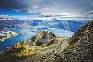 Hiking trail on mountain above lake landscape, scenic hike view over lake wanaka in new zealand, roys peak