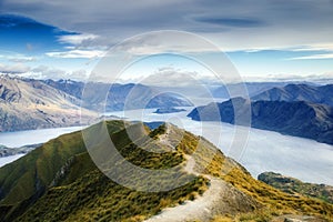 Hiking trail on mountain above lake landscape, scenic hike view over lake wanaka in new zealand, roys peak