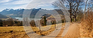 Hiking trail at Schliersberg mountain with view to lake Schliersee and bavarian alps in spring