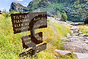 Hiking trail sign posted on the Wapama Falls trail, on the shoreline of Hetch Hetchy reservoir, showing points of interest and