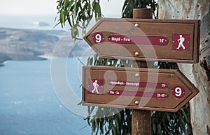 Hiking trail signs overlooking the Aegean Sea on Santorini