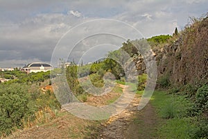 Hiking trail thorugh nature on Montjuic hill with olympic stadium of Barcelona in the background