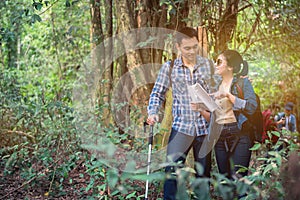 Love couple Hiking trail and trekking in the forest with friends.