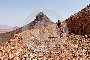 Hiking up the mount Zagora on a gravel road, mount Adafane in the background, Draa valley