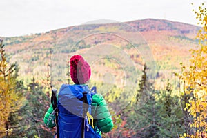 Hiking woman with backpack looking at inspirational autumn mount