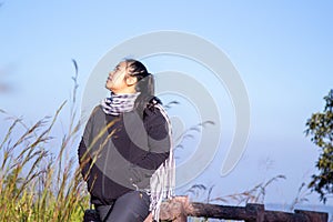 Hiking woman enjoying nature on top of mountain cliff with sunrise. Chubby woman outdoor. Relaxing in Nature