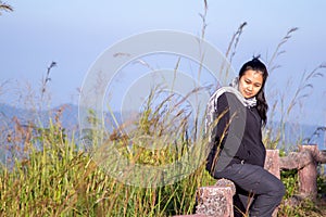 Hiking woman enjoying nature on top of mountain cliff with sunrise. Chubby woman outdoor. Relaxing in Nature