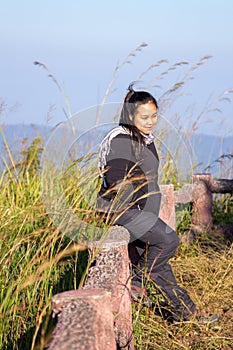 Hiking woman enjoying nature on top of mountain cliff with sunrise. Chubby woman outdoor. Relaxing in Nature