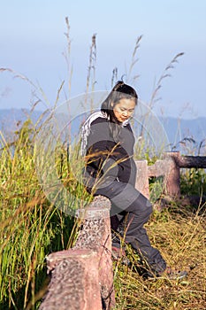 Hiking woman enjoying nature on top of mountain cliff with sunrise. Chubby woman outdoor. Relaxing in Nature.