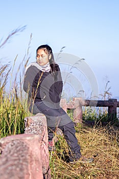 Hiking woman enjoying nature on top of mountain cliff with sunrise. Chubby woman outdoor. Relaxing in Nature