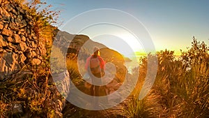 Hiking woman enjoying scenic sunrise from the Path of the Gods between Positano and Praiano on the Amalfi Coast, Campania, Italy