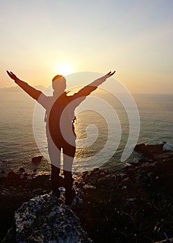 Hiking woman open arms to sunrise