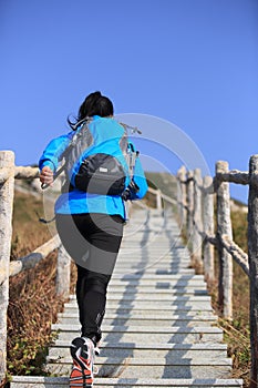 Hiking woman running at mountain stairs