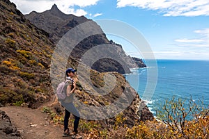 Hiking woman with scenic view of coastline of Anaga mountain range on Tenerife, Canary Islands, Spain. View on Cabezo el Tablero photo
