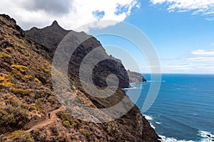 Hiking woman with scenic view of coastline of Anaga mountain range on Tenerife, Canary Islands, Spain. View on Cabezo el Tablero photo