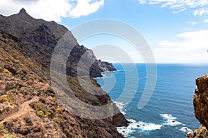 Hiking woman with scenic view of coastline of Anaga mountain range on Tenerife, Canary Islands, Spain. View on Cabezo el Tablero photo