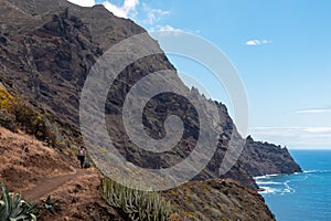 Hiking woman with scenic view of coastline of Anaga mountain range on Tenerife, Canary Islands, Spain. View on Cabezo el Tablero photo