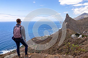 Hiking woman with scenic view of coastline of Anaga mountains on Tenerife, Canary Islands, Spain, EU. View on Roque de las Animas photo