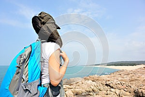 Hiking woman stand seaside rock