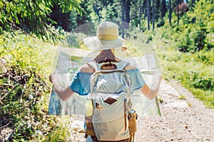 Hiking woman traveler with backpack checks map