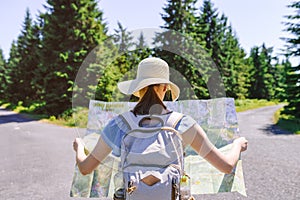 Hiking woman traveler at the crossroads with backpack