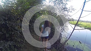 Hiking woman trekking in rainforest jungle. Rear back view of young female hiker walking on trek through rain forest