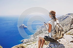 Hiking woman using smart phone taking photo, travel and active lifestyle concept