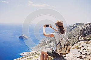 Hiking woman using smart phone taking photo, travel and active lifestyle conceptt