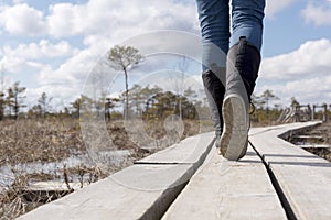 Hiking on wooden trail at Kemeri bog. Walking and trekking outdo