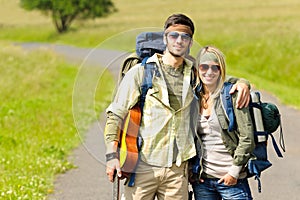 Hiking young couple backpack tramping asphalt road